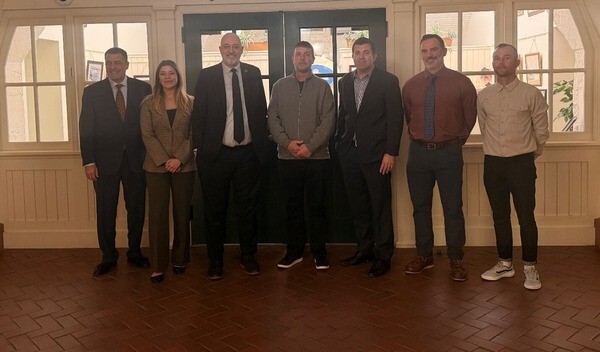 Rep. Click standing with 6 people