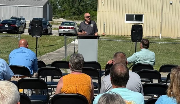 Rep. Click at a podium in district