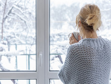 picture of lady looking out window at snow