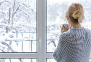 picture of person looking out home window at snow