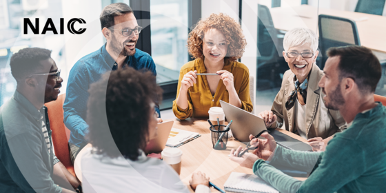 picture of people sitting at work table laughing 