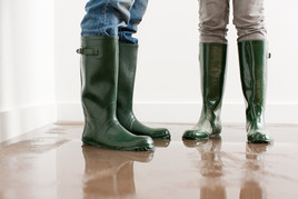 picture of two people wearing boots on flooded floor