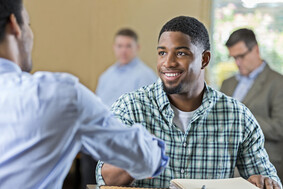 young man shaking hands at a job fair