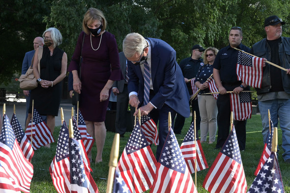 Governor DeWine and First Lady Fran DeWine place flags in the lawn of the Ohio Statehouse.