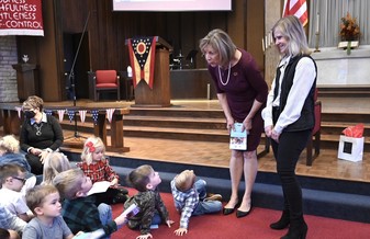 First Lady DeWine stands next to Senator Peterson's wife, Lisa, as she prepares to read a book from the Imagination Library.