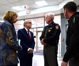 Governor DeWine speaks to a Nelsonville County Sheriff about a new grant funding for the local jail.