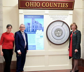 Governor DeWine and First Lady Fran DeWine pose by the new interactive exhibit which provides facts on all 88 of Ohio's counties.