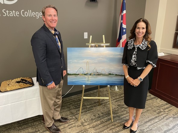 Lt. Governor and Second Lady Husted stand next to the Second Lady's painting of Cedar Point while they were in Mansfield on Thursday.