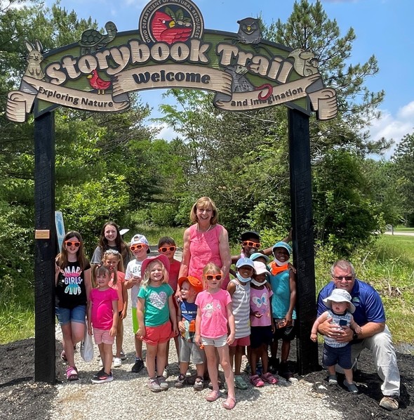 First Lady Fran DeWine and others stand at the entrance of the new Storybook Trail in Deer Creek State Park after the ribbon-cutting ceremony.