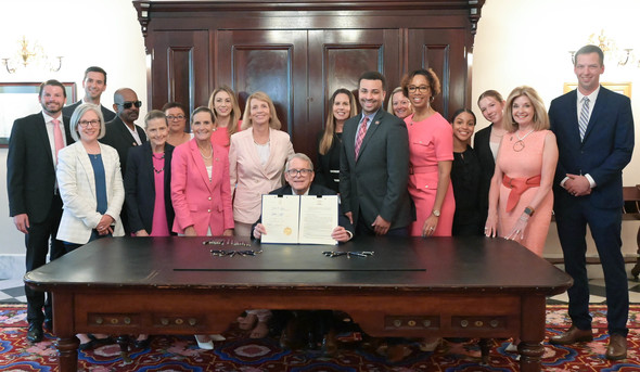 Governor DeWine holds up a newly singed House Bill 371, a bill sponsored by Representatives Jean Schmidt and Sedrick Denson.