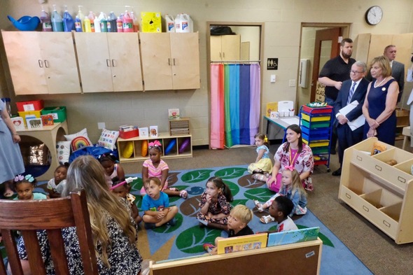 Governor Mike DeWine and First Lady Fran DeWine watch a group of preschool students listen to a story in a classroom