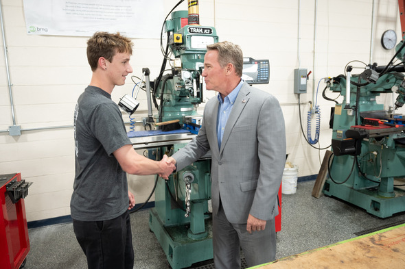 Husted shaking male student's hand