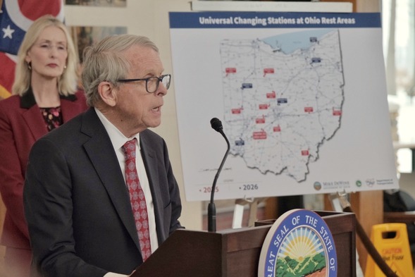 Governor DeWine speaks at Friday's event, in front of map of all Ohio rest areas set to get universal changing tables by 2026.