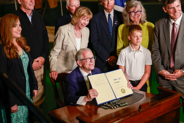 Governor DeWine presenting the signed copy of Senate bill 24.