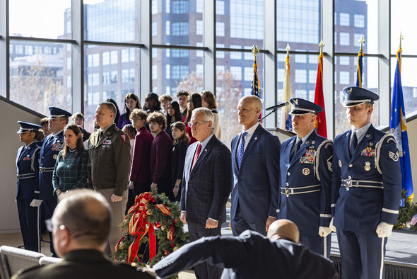 Ohio Lt. Governor Jim Tressel and other event participants pose for a photo alongside wreath featured in Monday’s wreath-laying ceremony.