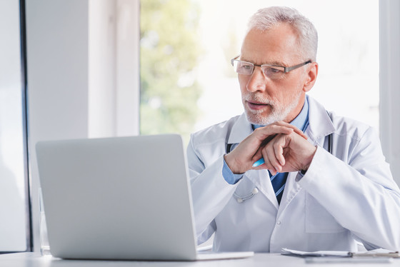 Older doctor working on a computer