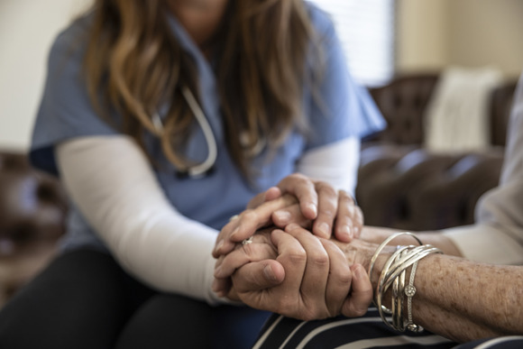 home health provider holding hands with patient