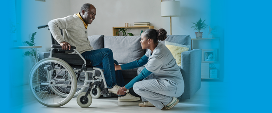 Man in a wheelchair receiving home health aid