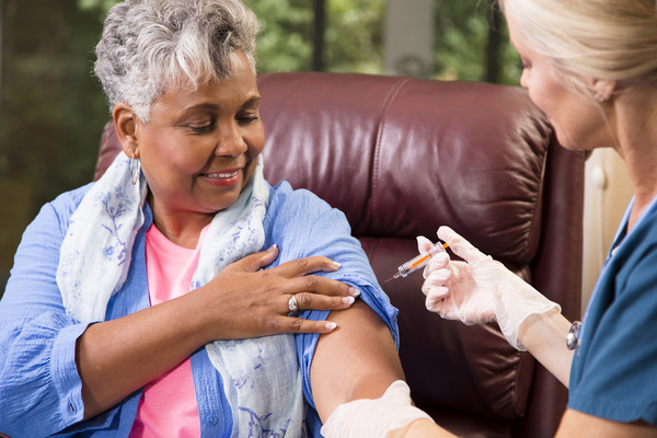 Nurse giving female patient a shot