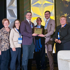 Six members of the Ohio Department of Medicaid leadership team accept an award on behalf of the department.