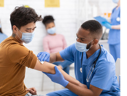 a man receives a vaccine from a nurse