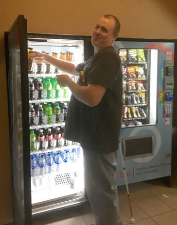 Tom Neal holding open the door of a vending machine