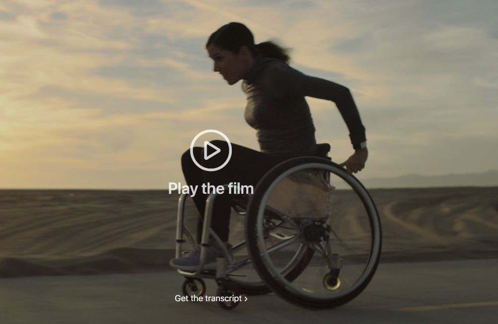woman in a wheelchair in desert - going fast with "play the film" arrow