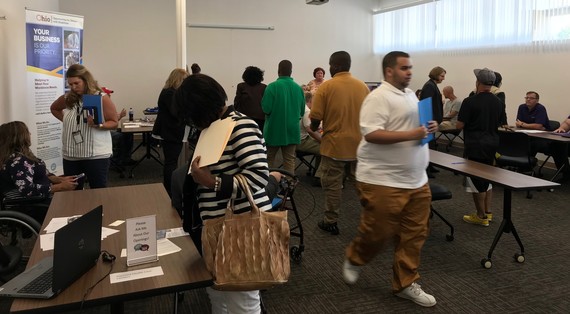 A photo showing multiple people at  hiring event meeting at tables and navigating event