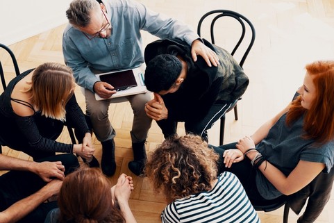 Photo of individuals sitting in a circle such as a support group