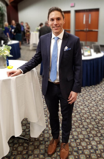 Photo of Mark Simon standing by a banquet table prior to speaking at an event