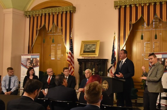 Photo from College2Careers event at the Statehouse.  Kevin Miller, Director of OOD at the podium. Other event participants seated to left of podium.