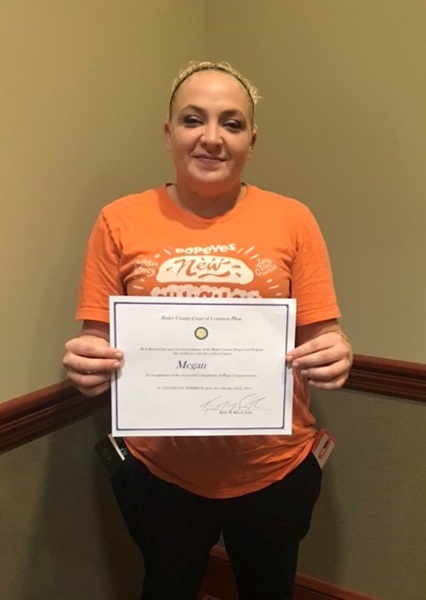 Megan shows off her Certificate of Completion for Phase One of her Recovery