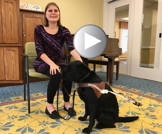 Photo of young woman in chair with her service dog