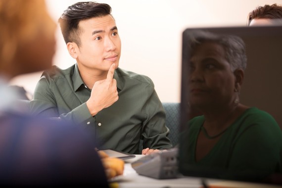 young Asian man using sign language in a small meeting