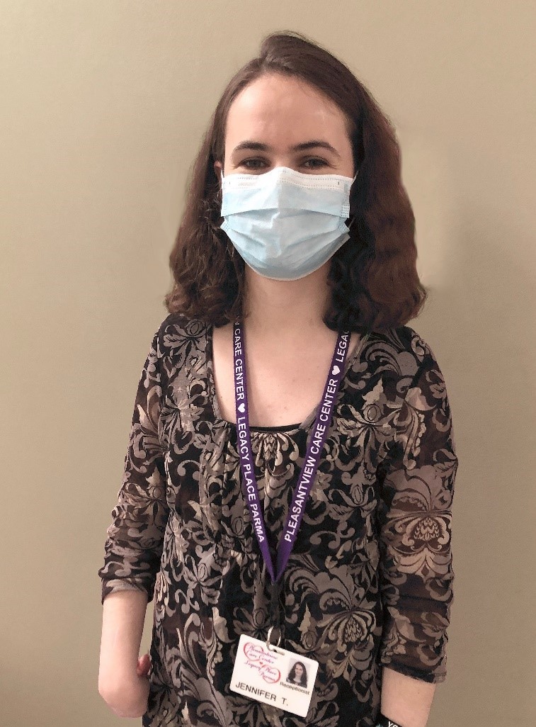 Young woman with PPE mask standing in front of a wall