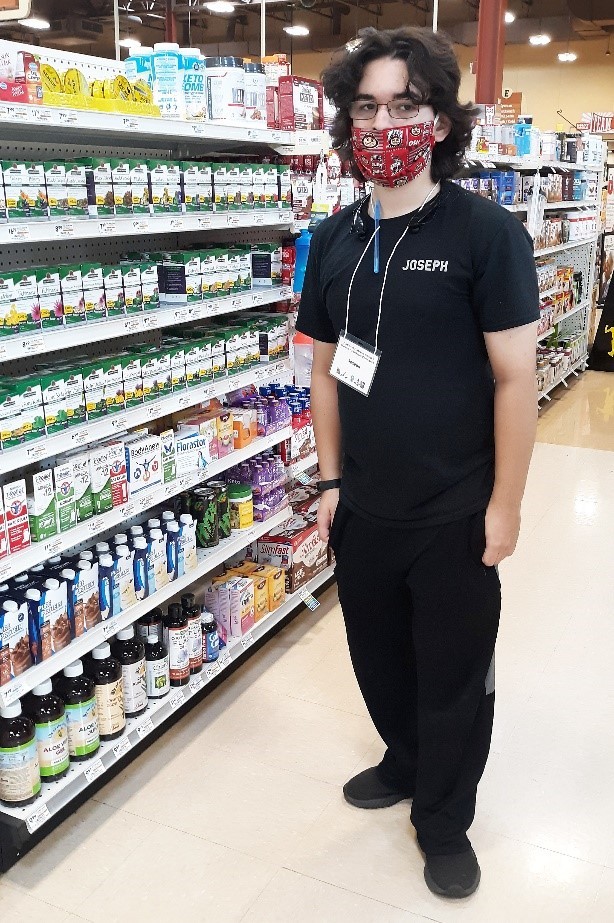  photo of a young man wearing a mask in a grocery store aisle