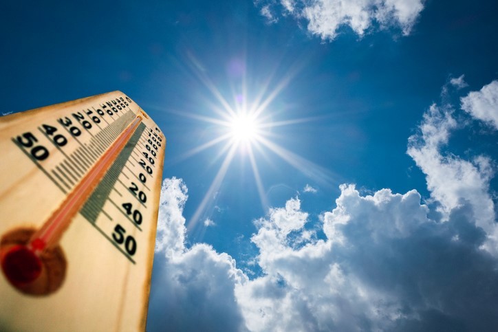 photo of thermometer with bright sun in the sky