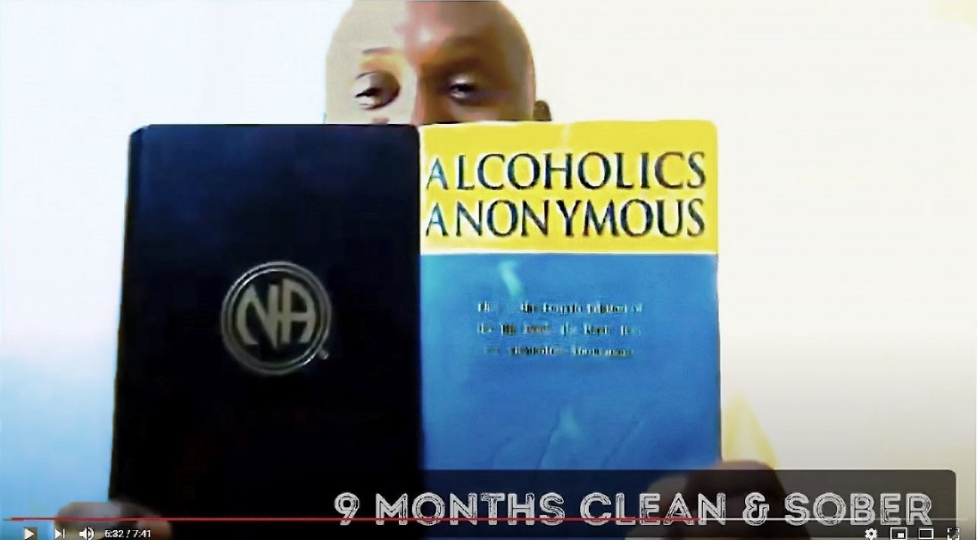 photo of African -American man holding an Alcoholics Anonymous book