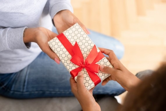 photo of hands - handing someone a wrapped gift