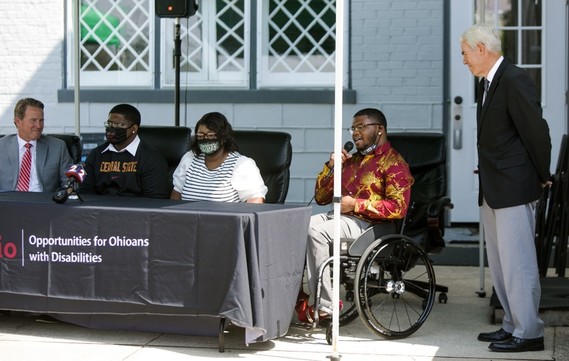 photo of 5 participants on stage from OOD C2C event with focus on student Andre Green speaking into microphone