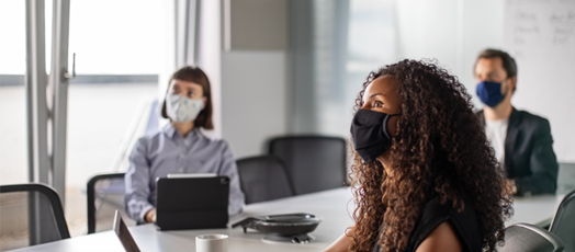 Image of three individuals sitting at conference room table