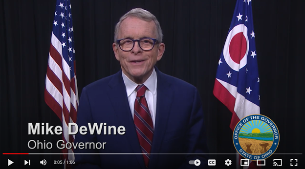 Photo of Governor DeWine with flags in the background