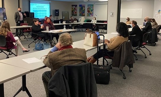 Photo of recent OOD council meeting of individuals sitting at tables listening to speaker