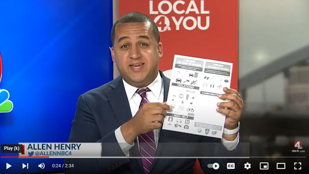 male news reporter holding up new communication card with Local 4 You sign in background