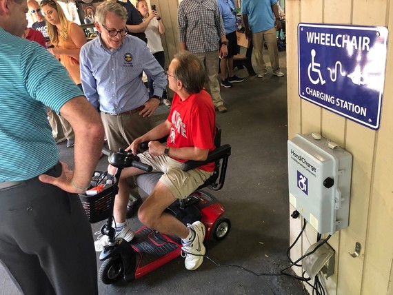 Governor DeWine talks to a gentleman charging his wheelchair during the 2019 Ohio State Fair.