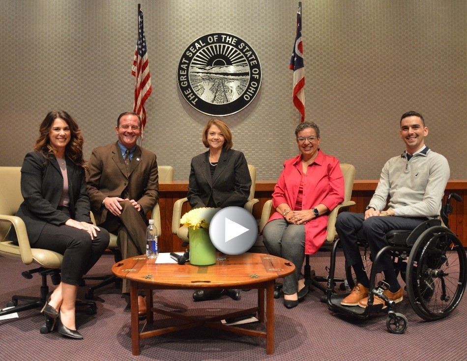 Photo of five people on a panel sitting and smiling