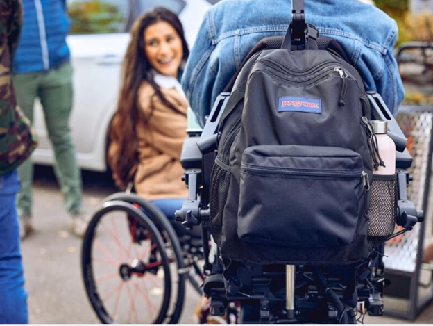 Photo of woman in wheelchair, smiling across from another peroson in a wheelchair