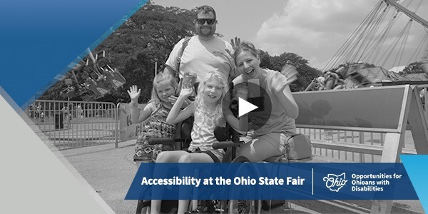 A family of four posing in front of a ride at the Ohio State Fair.