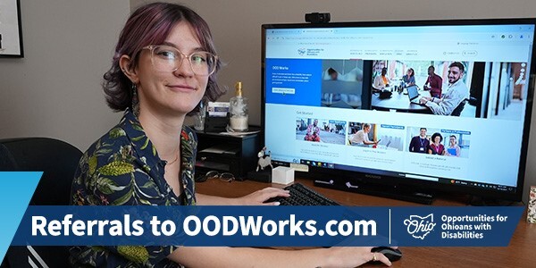 Individual working off a desktop computer and the OODWorks.com homepage on the screen display.