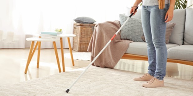 A person using a cane in a living area.